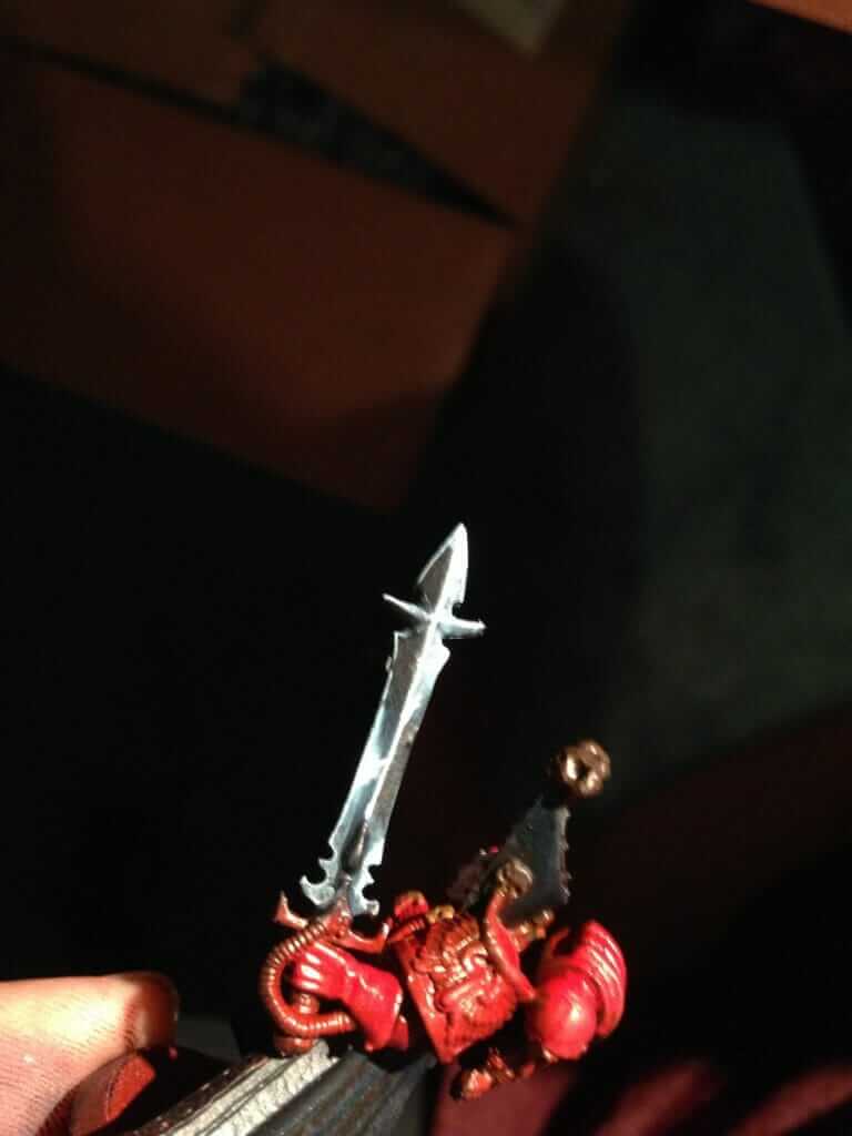 Highlighting the reflections of light on a power sword on a warhammer 40k model