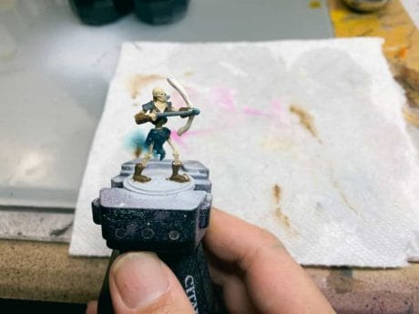 Citadel Paint Handle Review: Is It Worth It? - Citadel Painting Handle Review - Holding a skeleton RPG miniature with the painting holder