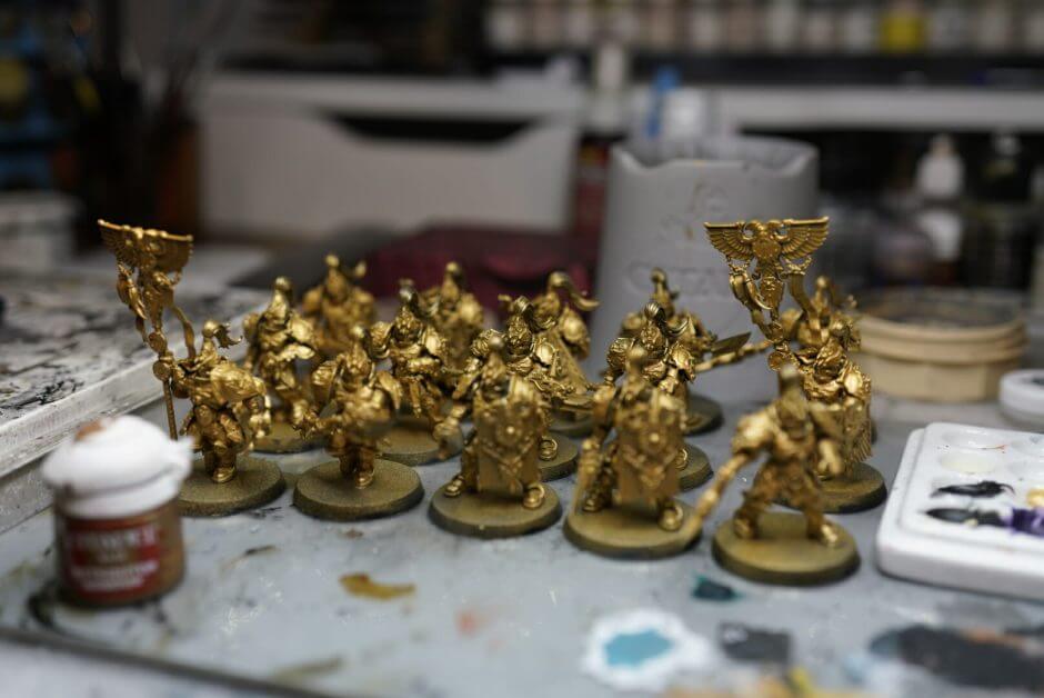 Magnifiers for Miniatures (Tips and Recommendation) - Row of miniatures on a workbench prepared for detail painting