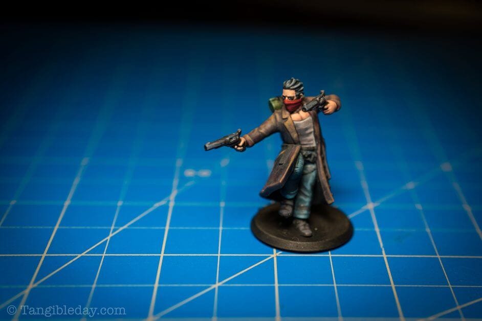 A gun mage miniature on a blue backdrop with a strong vignette. 
