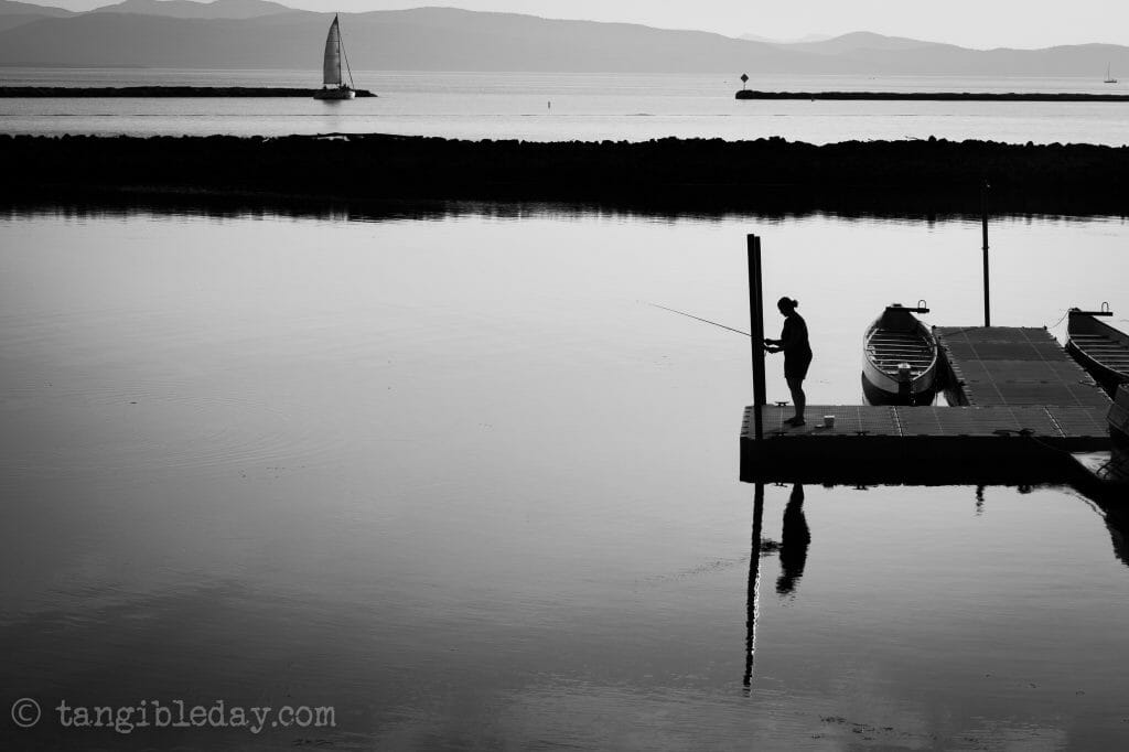 tranquil black and white photo of fishing in lake