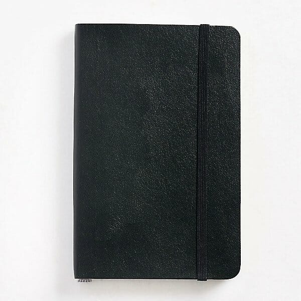 A top down view of a moleskine black notebook