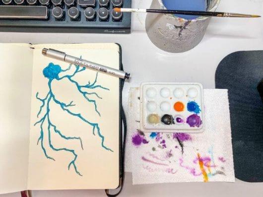 neuron doodles and art - drawing neurons and neuroscience art - the secret of complexity - a neuron grows from nothing - a drawing with pen and paper- nature must make sense - flat lay photography of neuron art sketchbook