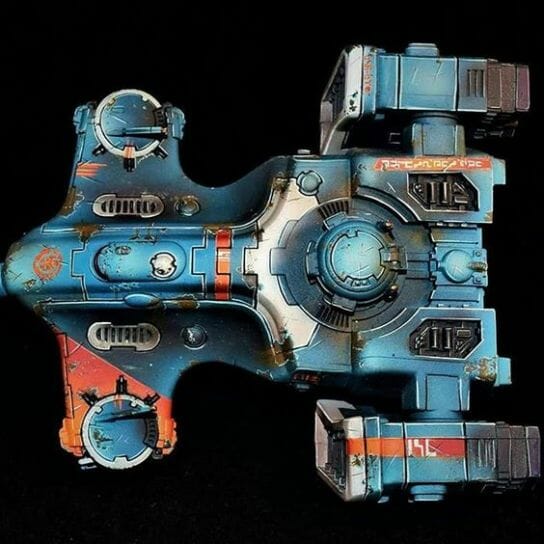How to Paint Model Tanks (8 Basic Steps) - painting tanks - how to paint model tanks - Top down view of tau army scale model tank with blue and orange accent color scheme
