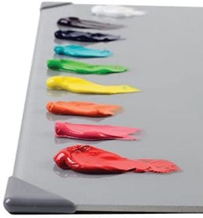 Colorful acrylic paints on glass palette surface 