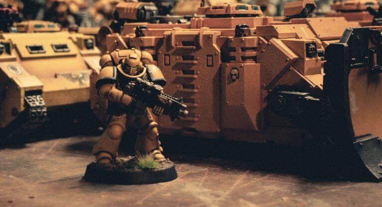 Close up imperial fist space marine with tanks in yellow. Dim lighting.