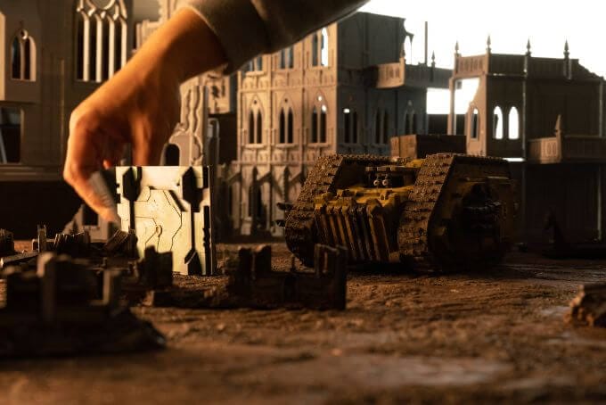 Redgrass games desk lamp review, redgrass games lamp review for painting miniatures, models, and art - My hand enters the scene of a wargaming photo