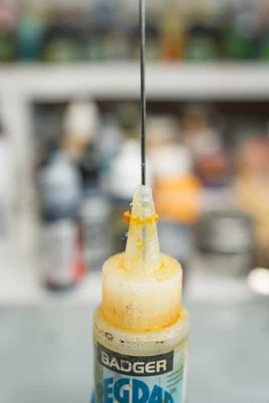 How to thin acrylic paint for airbrushes – how to thin paint for airbrushing miniatures and models – What and how to thin hobby paint for your airbrush - needle in regdab oil bottle