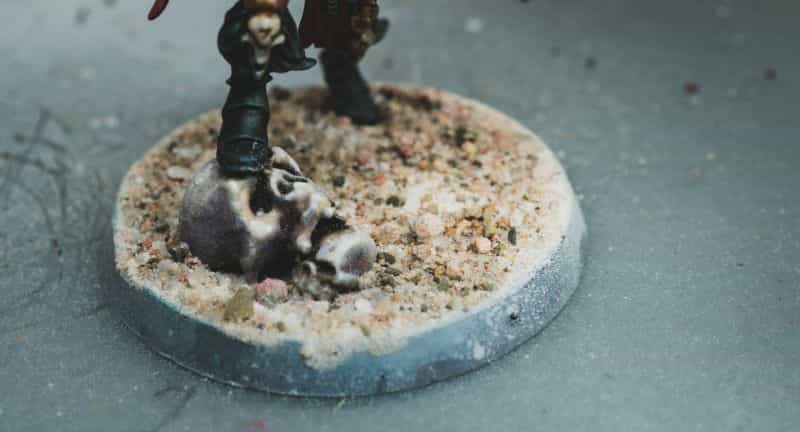 Miniature Basing Materials for Model Hobby Projects (Tips and Review) - best basing material for miniatures and models - Sand on base of a model close up with skull