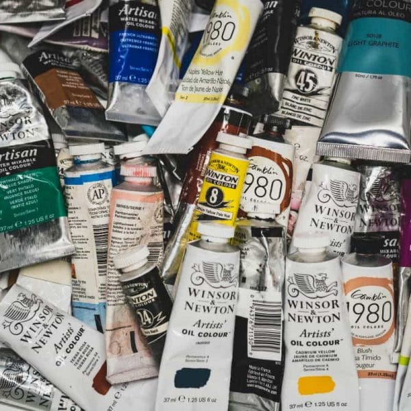 oil and acrylic paint tube storage solution - pile of paint tubes used in a drawer - best paint tube storage racks and displays - how to store paint tubes