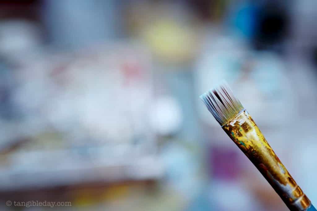 Close of a flat headed bristled brush for applying primer to models