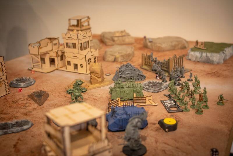 The History of Tabletop Wargaming - Miniature wargaming history through the ages, milestones and key points - Photo of warhammer 40k game played on tabletop with terrain features