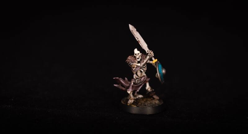 Best tabletop miniature games - Miniature wargaming - what is tabletop wargaming - popular wargames with miniatures - a skeleton miniature painted with black background