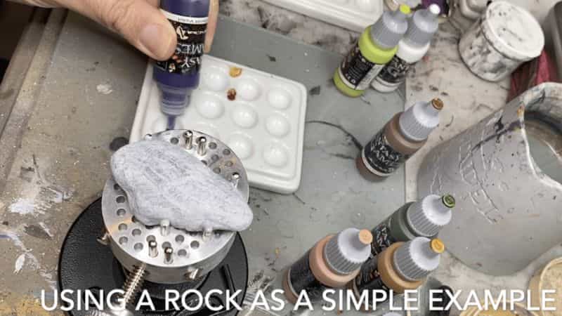Primed rock surface used as a demonstration model for dry brushing miniatures.