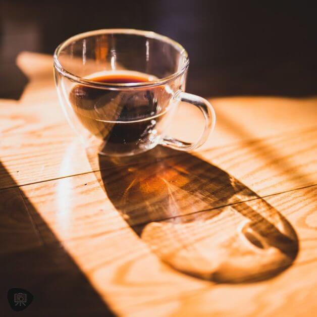 Miniature Basing Materials for Model Hobby Projects (Tips and Review) - best basing material for miniatures and models - Glass cup of black coffee with natural warm sunlight cast on wood floor