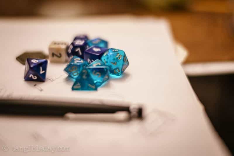 SMONEX Dice Tower Review - Close up of blue and white polyhedral dice with pencil nearby for DND or other TTRPG gameplay session in progress