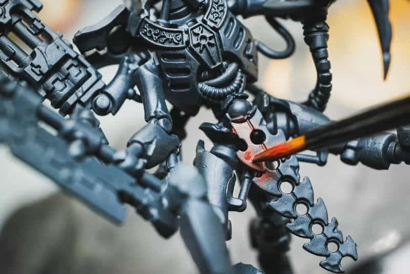 How to Paint Plastic Miniatures (Step-by-Step) - brush work up close with red pain on a plastic necron model