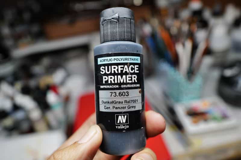 How to Paint Model Tanks (8 Basic Steps) - painting tanks - how to paint model tanks - holding a vallejo surface primer bottle