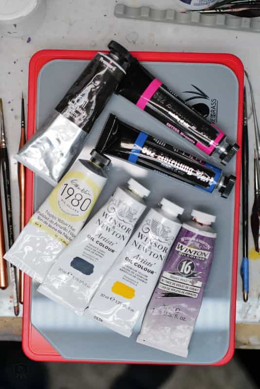 Best Kind of Paint for Miniature Painting? - acrylic paint, oil paints, scale modeling, painting miniatures - Paint tubes top down on a hobby desk top surface
