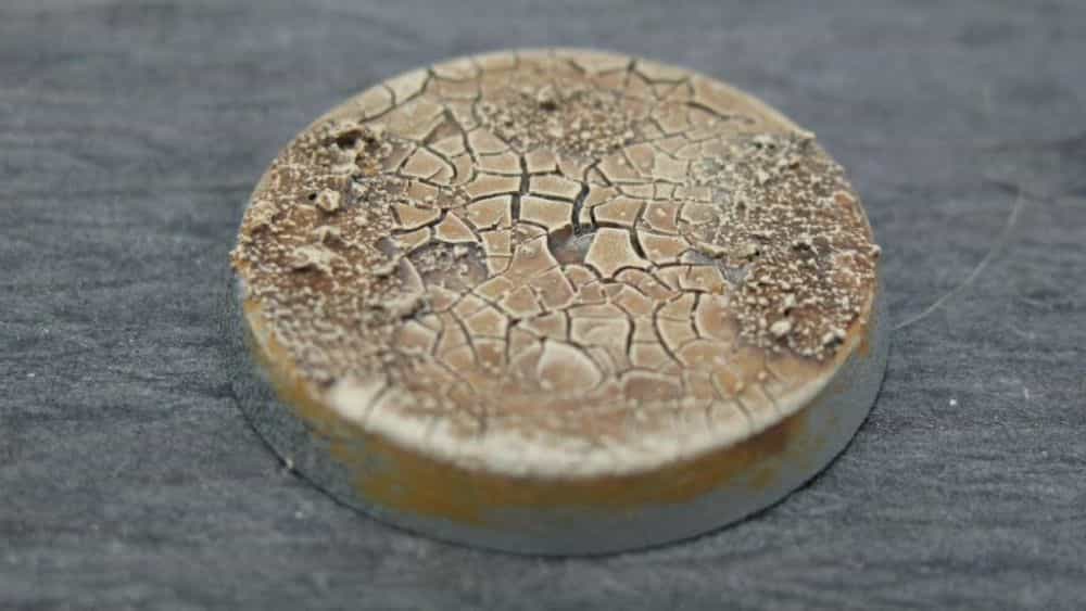 Miniature Basing Materials for Model Hobby Projects (Tips and Review) - best basing material for miniatures and models - crackle effect on a round plastic base with brow hue and drybrush highlights