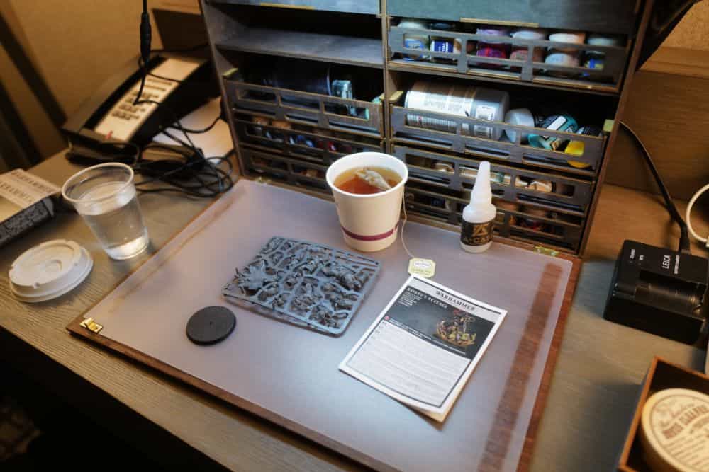 Portable painting and assembly workstation deployed on a desk in a hotel room