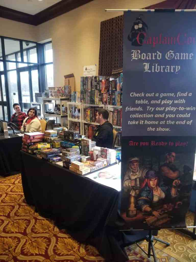 Running a Successful Hobby Gaming Convention: The Hidden Magic and Mayhem Behind CaptainCon - Board Game Library banner and table