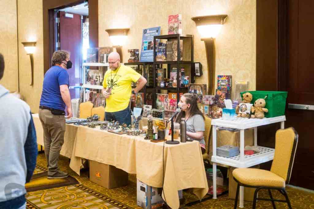 Running a Successful Hobby Gaming Convention: The Hidden Magic and Mayhem Behind CaptainCon - vendors at a table discussing things