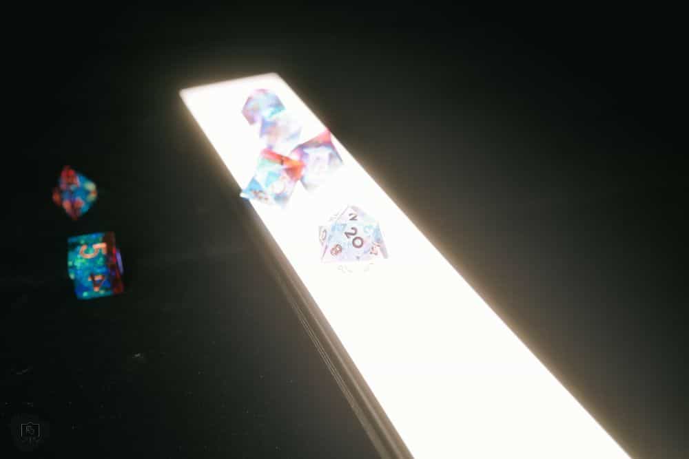 Frontier Wargaming The Hobby Deck Review - an LED light under illuminating clear acrylic polyhedral dice for an RPG