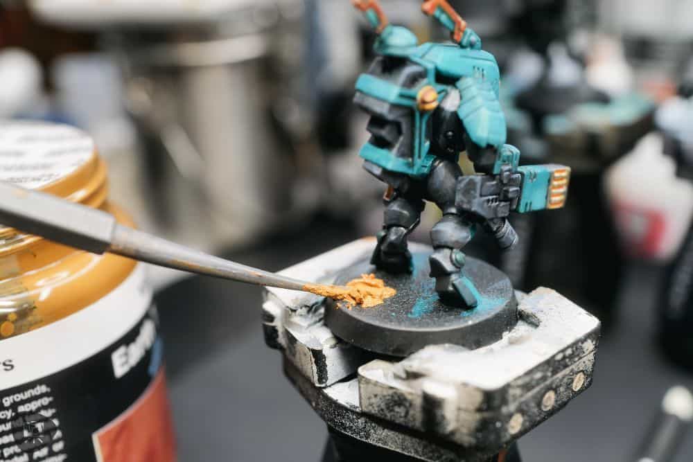 How to Paint Plastic Miniatures (Step-by-Step) - applying the Vallejo texture medium to the miniature's base with a small spatula.