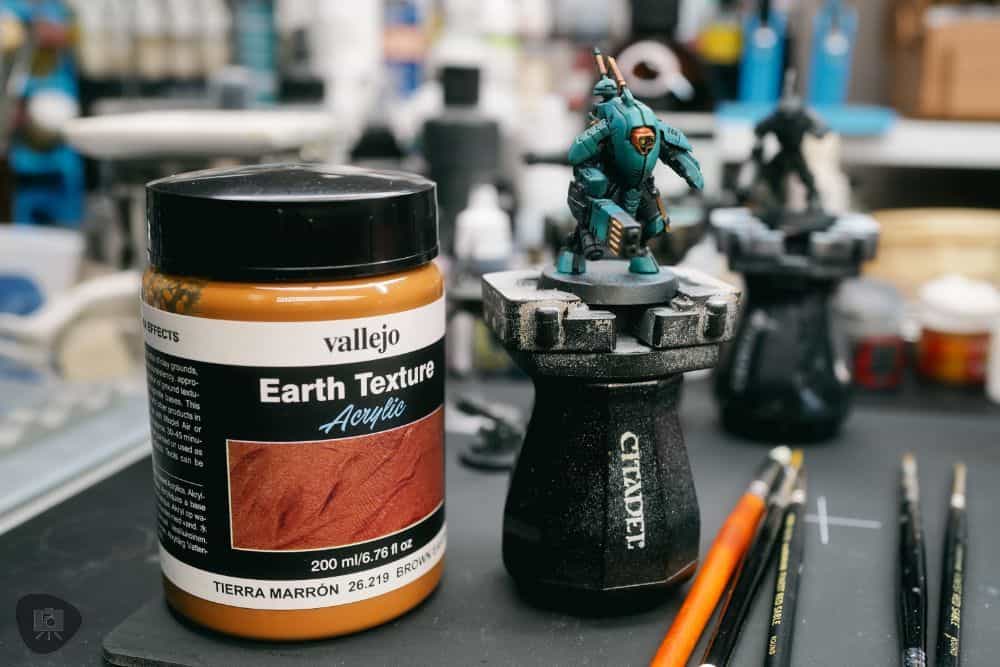 How to Paint Plastic Miniatures (Step-by-Step) - Vallejo texture mud next to the model.