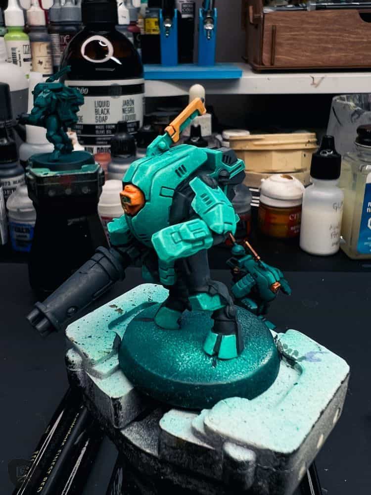 How to Paint Plastic Miniatures (Step-by-Step) - example of hard edge highlighting around the teal armor plates of this plastic warhammer 40k model