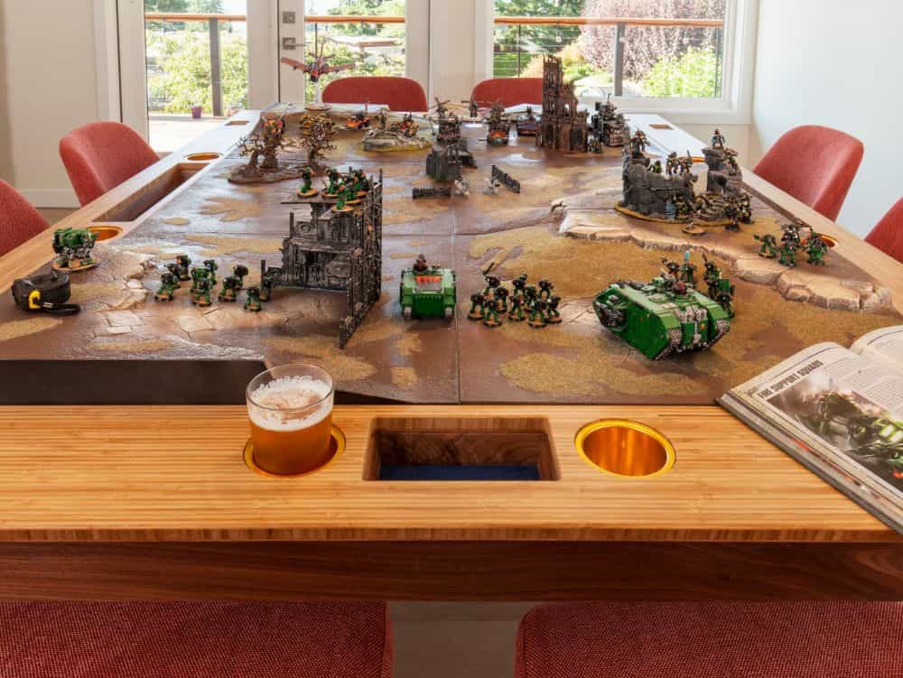 Warhammer 40k on the converted tabletop with miniatures and space marines and a mug of beer