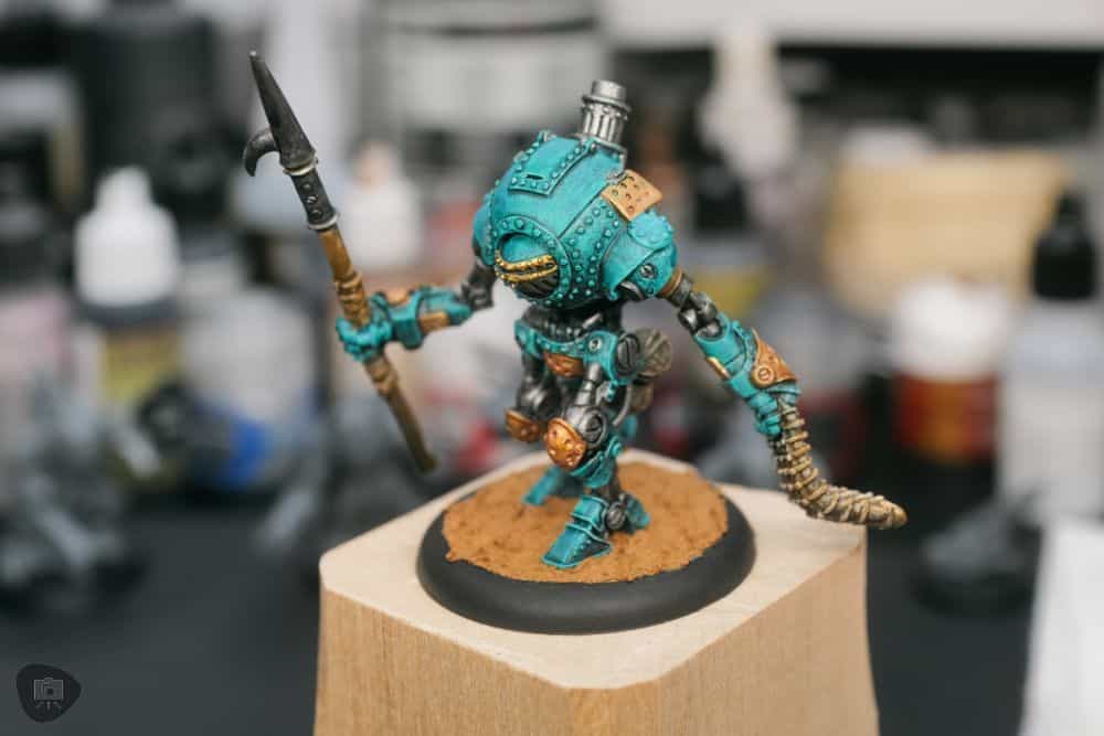 Painted sci-fi miniature on a textured dirt base made to resemble a Citadel-style basing effect using tile grout.