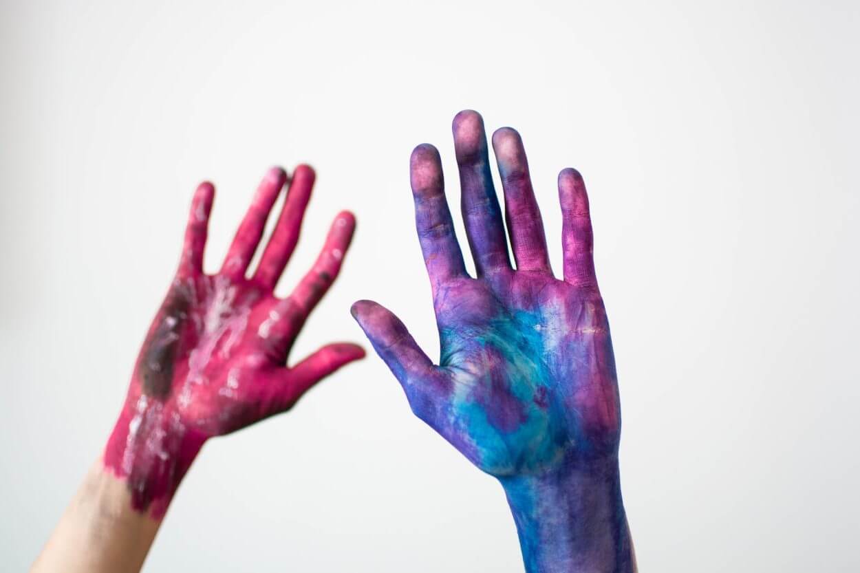 two hand filled with paint