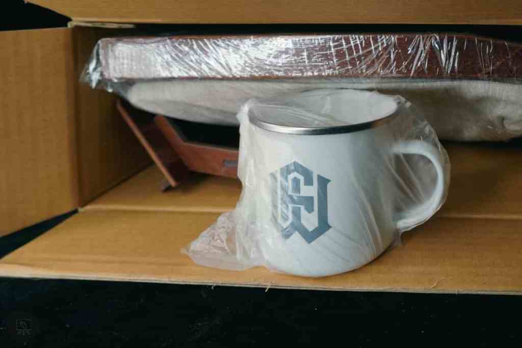Frontier Wargaming The Hobby Deck Review - portable hobby workstation - unwrapping the hobby deck from the box and the metal mug up front