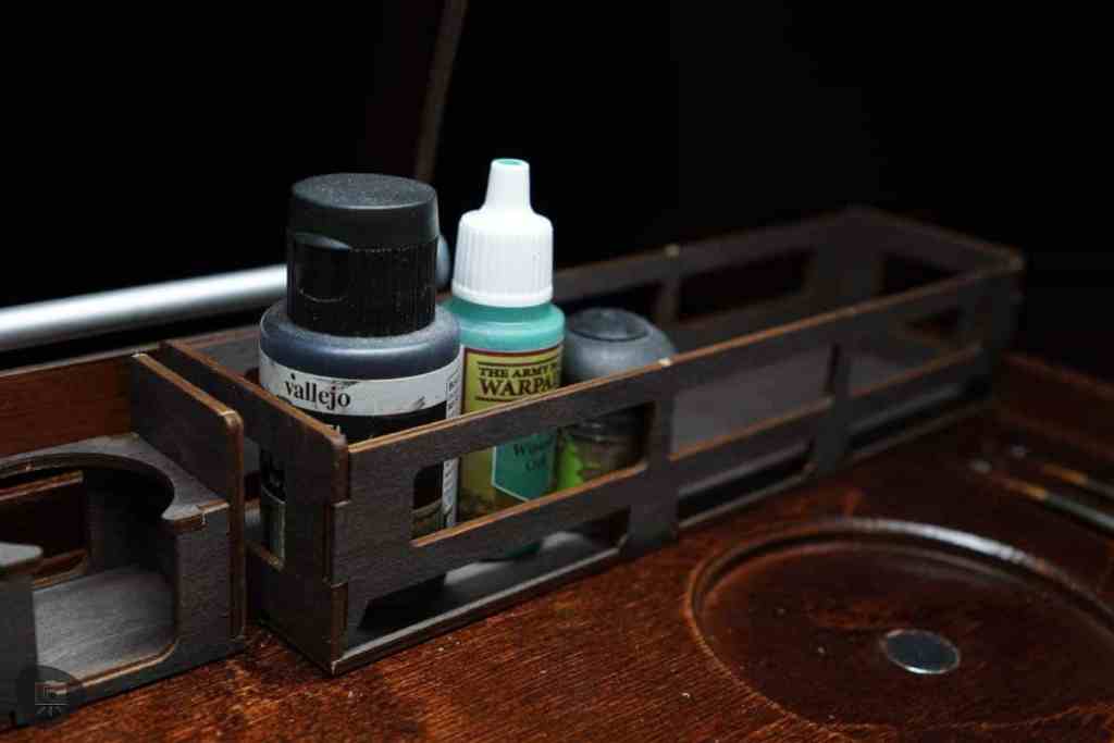 Frontier Wargaming The Hobby Deck Review - Miniature hobby brand paints in the shelf on top of the hobby deck