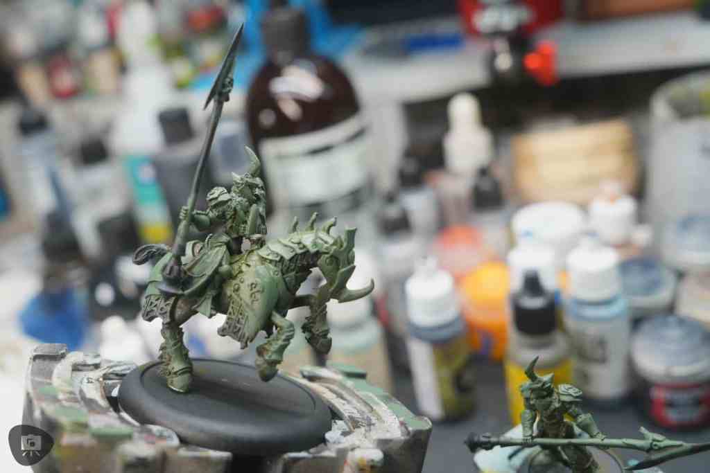 Sideview of the base coat on the miniature in green color acrylic