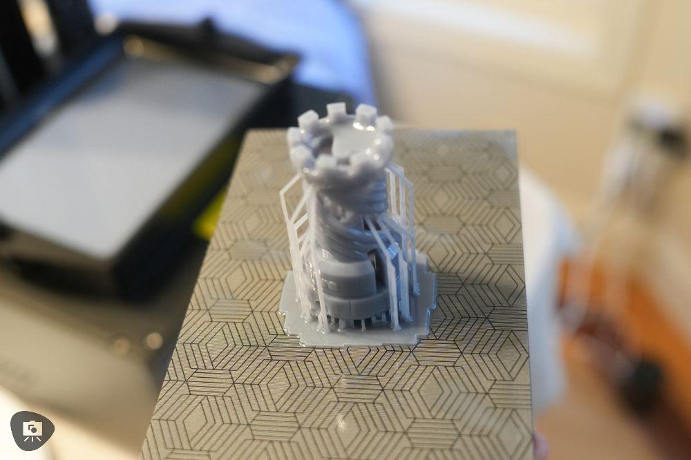 Resin-printed tower model on the build plate showing intricate support structures

