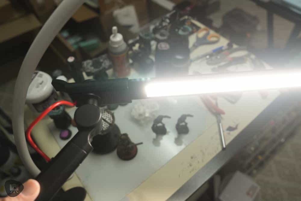 Bright Redgrass SOLO LED lamp turned on above miniature painting workspace